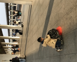 火车站台上收拾背包的小男孩